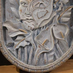 Bas-Relief Skulptur eines stilisierten Gesichts mit Blumen aus Holz, 20. Jh