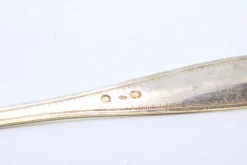 Silberner Streulöffel mit Reliefs und Griffgravur