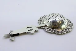 Silbernes Teesieb mit Blumenmotiven und Mühlengriff