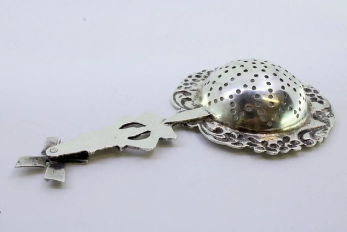 Silbernes Teesieb mit Blumenmotiven und Mühlengriff