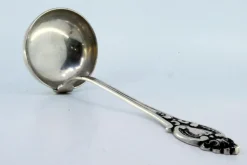 Silberne Suppenkelle mit Griffrillen und Monogrammkarte