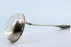 Silberne Suppenkelle mit Griffrillen und Monogrammkarte