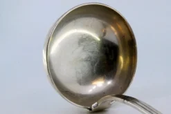 Silberne Suppenkelle mit Griffrillen und Monogrammkarte