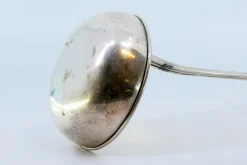 Silberne Suppenkelle mit Griffrillen und Monogrammkarte