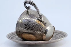 Tasse und Untertasse aus Neusilber mit gravierten Blumenmotiven und Monogrammkarte, 2 . Set